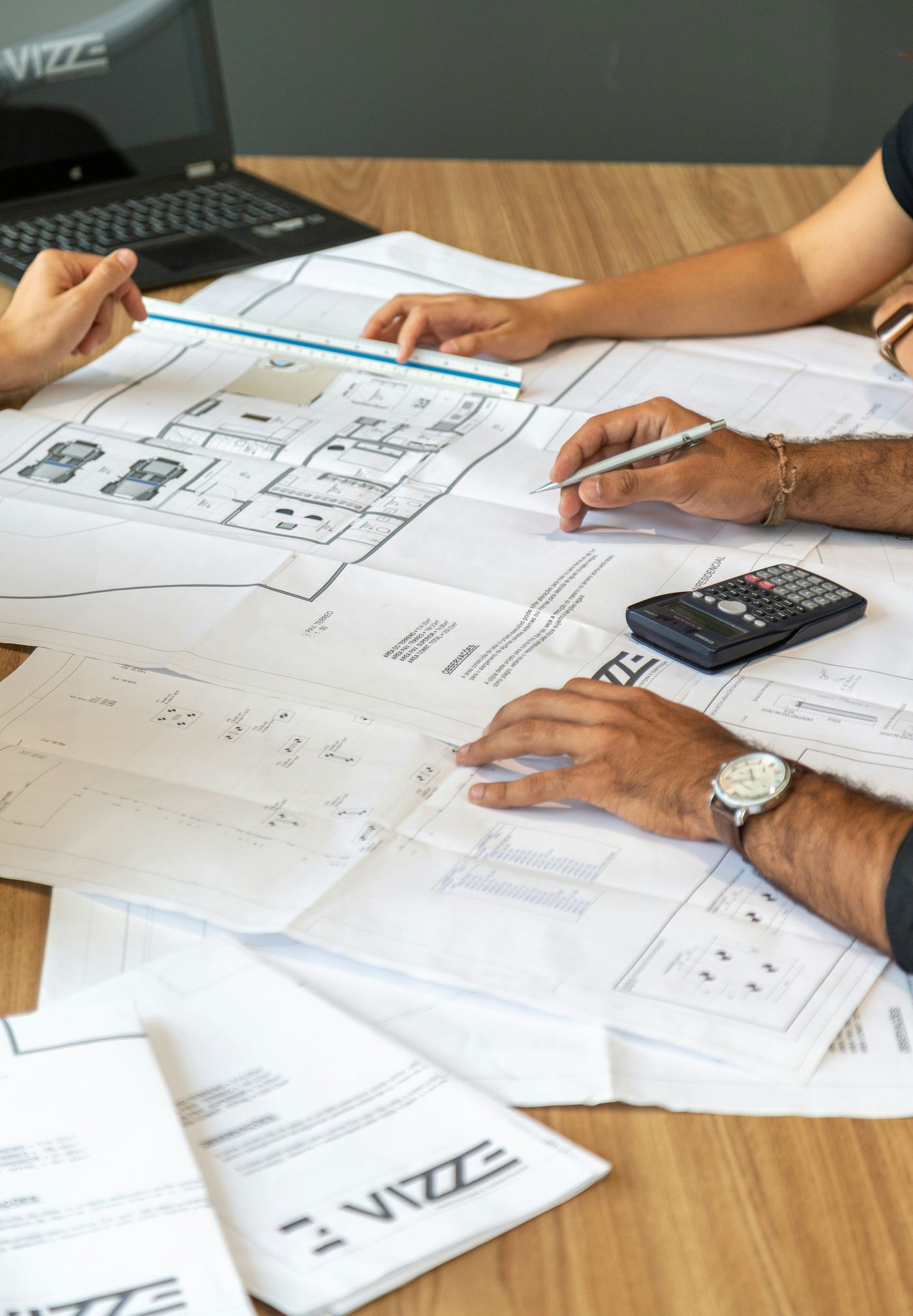 Project team reviewing architectural blueprints and calculations